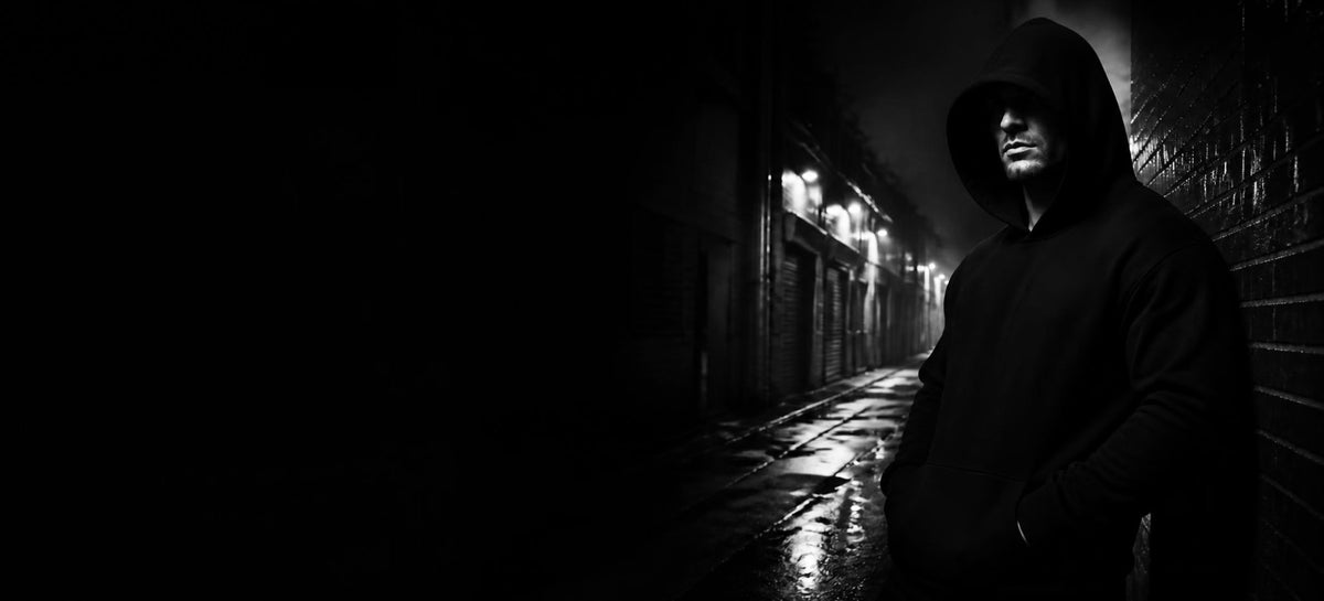 Mann i svart hettegenser i en mørk, våt bakgate om natten – 3AM